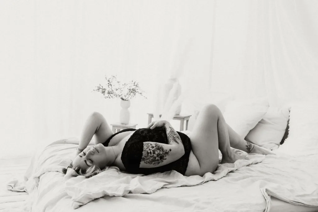 Frau im schwarzen Body räkelt sich im Bett beim Boudoirshooting München